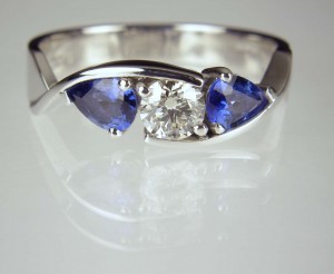 Round brilliant cut diamond 0.42ct set with a matched pair of pear cut sapphires totalling 0.8ct mounted in platinum