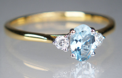 Aquamarine & diamond ring in 18ct yellow gold - Pretty oval aquamarine 6x4mm weighing 0.38ct, flanked by a 0.11ct pair of round brilliant cut diamonds G colour VS clarity, mounted in 18ct white gold on an 18ct yellow gold band. Ring is size N.