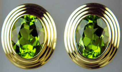 Peridot oval earstuds in 9ct yellow gold - 3.75ct pair of fine quality oval peridots set in an elegant gold ribbed rubover setting. Earstuds are 14x12mm. Mounts are 9ct yellow gold.