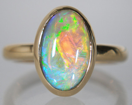 Black opal ring in 18ct yellow gold - 2.33ct oval black opal from Lightning Ridge, New South Wales, Australia, rubover set in 18ct yellow gold ring.
