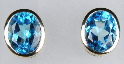 Blue topaz earstuds in 9ct yellow gold - 10x8mm oval Swiss blue topazes rubover set in 9ct yellow gold earstuds. These earstuds are included in our 20 year anniversary sale and are discounted by 50%. They are now £187.5. What a bargain!