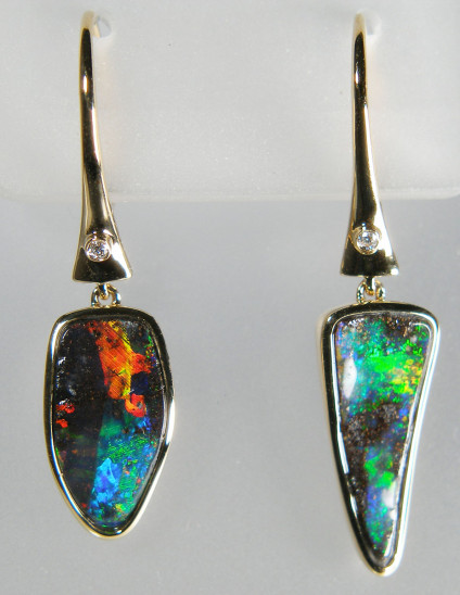 Boulder opal & diamond drop earrings in 18ct yellow gold - Vividly coloured 4.27ct pair of Australian boulder opals, rubover set in 18ct yellow gold and suspended from continental style earhoops set with 0.02ct diamonds. The earrings measure 8 x 34mm.
