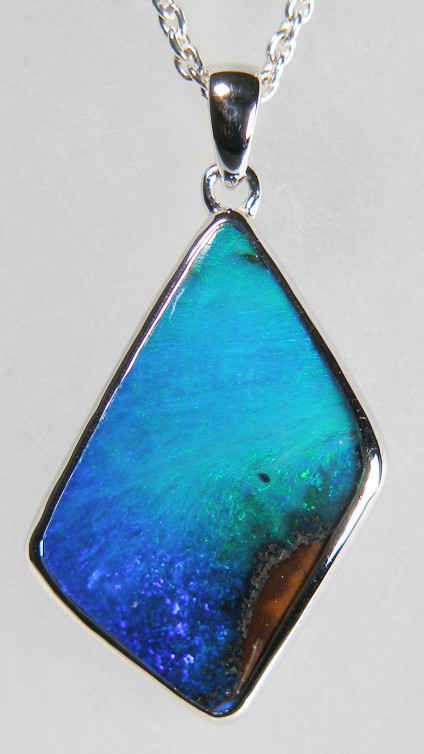 Boulder opal pendant in silver - Beautiful turquoise and blue boulder opal from Queensland, Australia, weighing 8.11ct, rubover set in silver pendant. Chain is available for separate purchase. The pendant is 15 x 30mm.