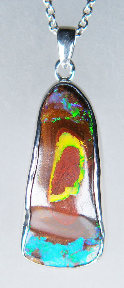 Boulder opal pendant in silver - 13.77ct spectacular boulder opal from Queensland, Australia, rubover set in silver. Pendant measures 10 x 30mm. Chain is available for separate purchase.