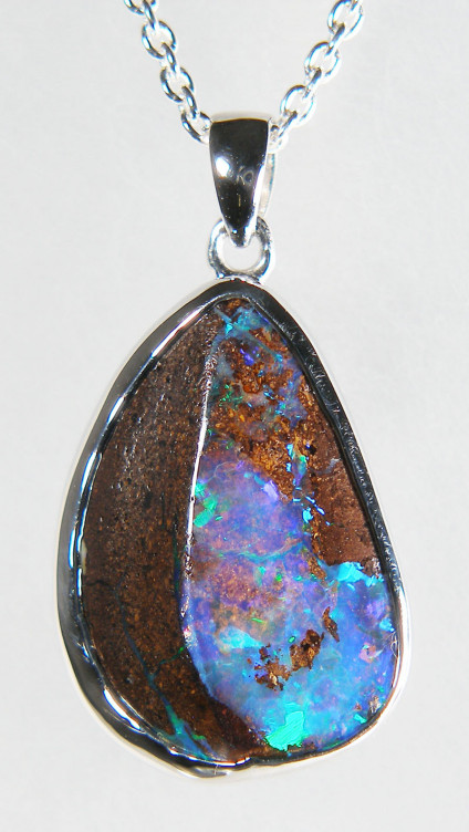 Boulder opal pendant in silver - Stunning blue & green drop shaped boulder opal weighing 12.91ct, from Queensland, Australia, rubover set in silver pendant. The pendant measures 15x25mm. The chain is available for separate purchase.