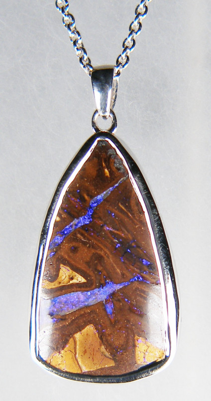 Boulder opal pendant in silver - 17.67ct pear shaped boulder opal from Queensland, Australia, rubover set in silver pendant. Pendant measures 15x32mm. The chain is available for separate purchase
