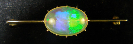 Vintage brooch or tie pin in 9ct yellow gold - 10-15mm clear crystal opal cabochon with fabulous play of colour set in 9ct brooch. Total length 39mm.