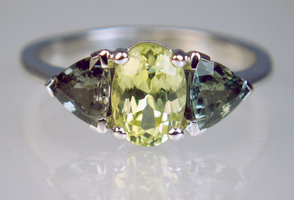 Chrysoberyl & green sapphire ring in 18ct white gold - 1.13ct oval yellow chrysoberyl flanked by a 0.91ct matched pair of trillion cut green sapphires in 18ct white gold