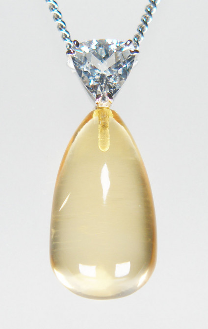Citrine & goshenite pendant in 9ct white gold - 10x18mm polished drop shaped citrine suspended from a 0.70ct trillion cut goshenite (colourless beryl), on an 20" curb link chain, all in 9ct white gold. The pendant is 27mm long. This pendant and chain is included in our 20th anniversary 50% sale and now costs £295.
