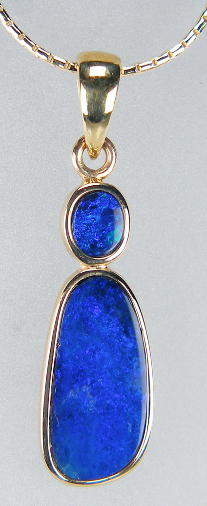 Doublet opal pendant in 9ct yellow gold - Dark purplish blue doublet opal pair rubover set in 9ct yellow gold. Pendant measures 30 x 8.5mm. The price excludes the chain.