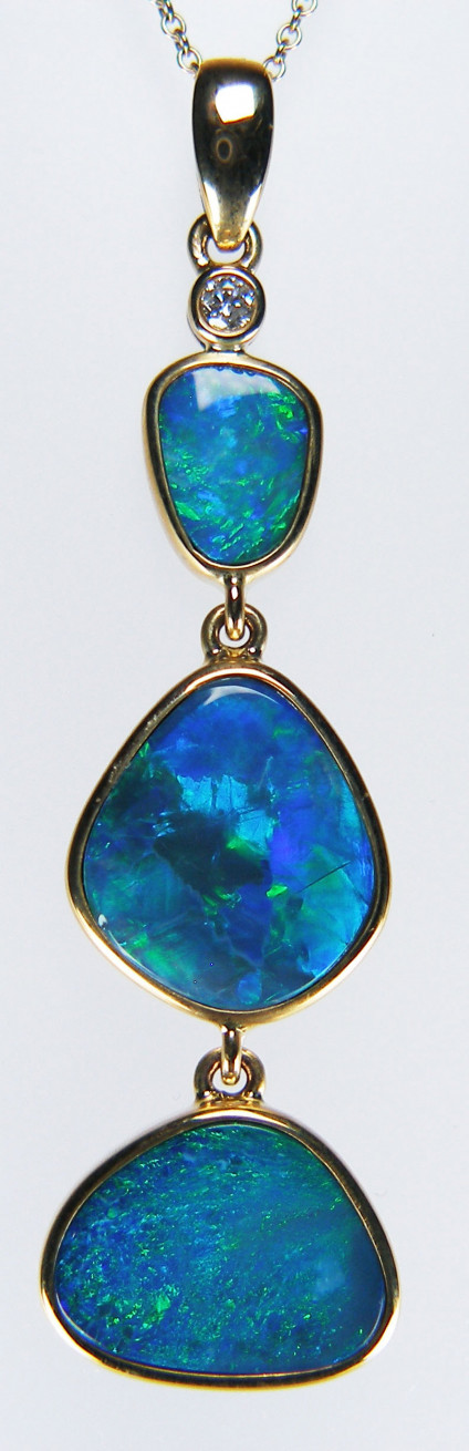 Doublet opal & diamond pendant in 9ct yellow gold - Lovely drop pendant with three rubover set opal doublets in striking turquoise, blue and green hues suspended from a tiny diamond. The pendant is 48mm long and is in hallmarked 9ct yellow gold. The chain is available for separate purchase.