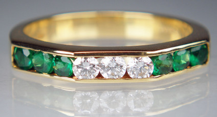 Emerald & diamond ring in yellow gold - 6 round cut emeralds channel set with 3 round brilliant cut diamonds in 18ct yellow gold ring. Finger size M 1/2. Superb qulity emerald really make this piece stand out