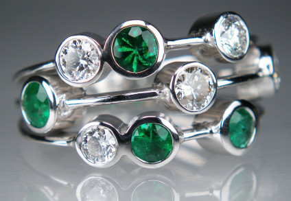 Emerald & diamond ring in 18ct white gold - five round brilliant cut diamonds and four emeralds rubover set in 18ct white gold ring. Total of 0.70ct emeralds and 0.80ct of diamonds. Ring size O.