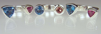 Between Finger Rings - Range of rings set with pink tourmalines & blue topaz.  The stones sit between the fingers.  Most unusual, and comfortable to wear!  All set in silver