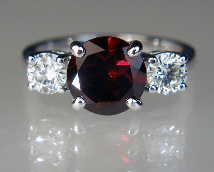 Round garnet & diamond three stone ring in 18ct white gold - 3.27ct round garnet 9mm in diameter flanked by a matched pair of round brilliant cut diamonds in G/H colour SI2 clarity totalling 0.82ct, set in 18ct white gold