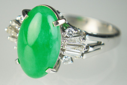 Jade & diamond ring in platinum - Beuatiful, untreated (certified) jadeite jade oval cabochon measuring 13 x 8.3mm, flanked by a 0.27ct matched pair of tapered baguette diamonds, all set in platinum. This is a pre-loved item and has been checked by our gemmologist and goldsmith. It comes with a 6 month warranty.
