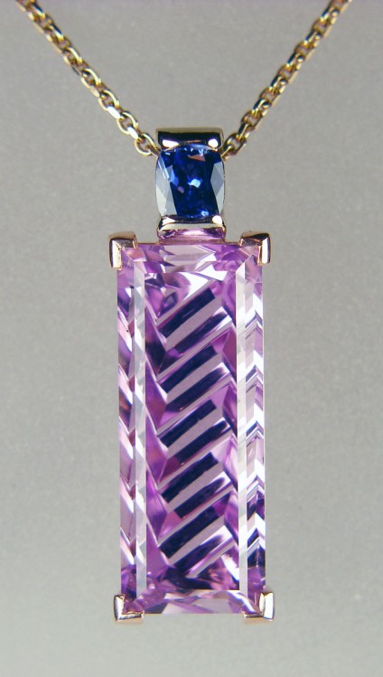 Kunzite & sapphire pendant in 18ct white & rose gold - 11.76ct concave cut rectangular kunzite mounted in 18ct rose gold, and a 0.4ct cushion cut natural blue sapphire in 18ct white gold.