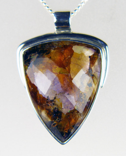 Blue John pendant in silver - Unusual brownish purple Blue John pendant set with a faceted gemstone of Derbyshire fluorspar from Castleton. The gemstone is backed by a mother of pearl slice which gives it lustre and light reflectance. The pendant is mounted in silver and is 30 x 20mm.