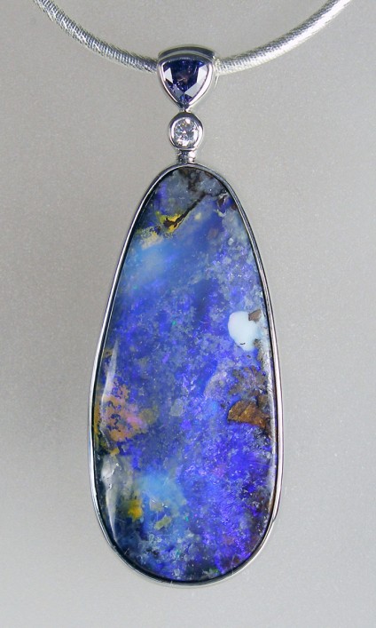 Boulder opal, sapphire & diamond pendant in silver - 54.94ct pear shaped Australian boulder opal set with 0.70ct triilion cut purple sapphire & 0.12ct round brilliant cut diamond in a rubover silver pendant