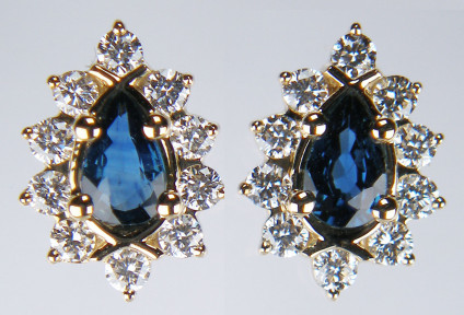 Pear shaped dark sapphire & diamond earstuds in 9ct yellow gold - 0.49ct pair of pear cut sapphires with bright diamond halo of 0.33ct round brilliant cut diamonds all claw set in 9ct yellow gold. Earstuds are 10mm long.