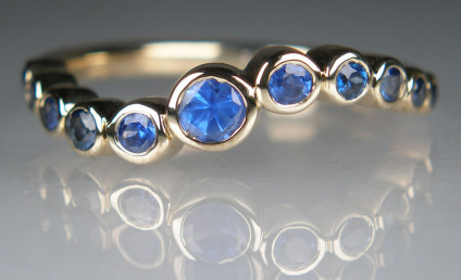 Sapphire ring in 9ct yellow gold - Cornflower blue round cut sapphires rubover set in 9ct yellow gold ring. Total sapphire weight is 0.53ct. The ring is size M.