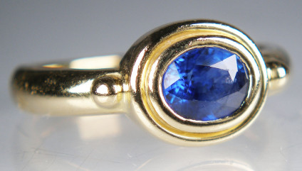 Sapphire set in Roman style 18ct yellow gold ring - Beautiful blue oval sapphire of approximately 1.25ct in a rubover set vintage Roman style ring in 18ct yellow gold. This ring is pre-loved and has been carefully inspected by our team.