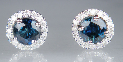Sapphire & diamond earstuds in 9ct white gold - 0.81ct pair of round cut blue sapphires in diamond set halos. Total diamond weight is 0.12ct . Earstuds are 6mm in diameter