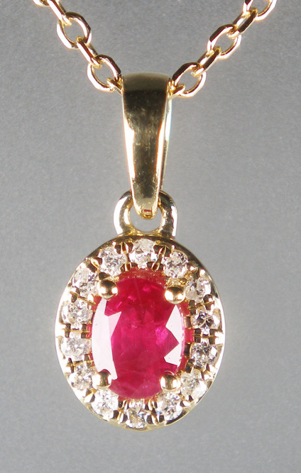 Ruby & diamond pendant in 18ct yellow gold - 0.23ct oval ruby in a halo of diamonds, total diamond weight 0.06ct, mounted in 18ct yellow gold. Pendant is 13mm long. The pendant is £325 and the 18ct yellow gold chain is £120.