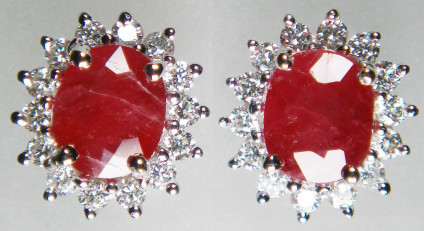 Ruby & diamond cluster earstuds in 9ct white gold - Oval ruby pair - included natural heat treated but NOT glass filled - weighing 1.82ct surrounded by a halo of round brilliant cut white diamonds weighing 0.39ct. All gems are claw set in 9ct white gold. The earstuds measure 9 x 10mm. 