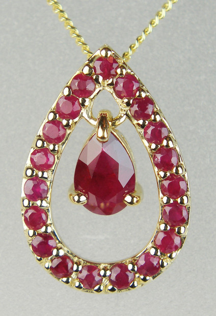 Ruby pear shaped pendant in 9ct yellow gold - 0.83ct of rubies in this stylish pear shaped pendant, made up of a single moving pear cut ruby set in a ruby set pear shaped frame in 9ct yellow gold, suspended from an 18" 9ct yellow gold chain. This striking pendant is 16mm long & 11mm wide.