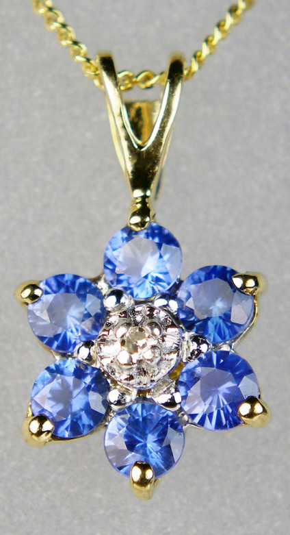 Sapphire & diamond pendant in 9ct yellow gold - Pretty mid blue round brilliant cut sapphires surrounding a central round brilliant cut diamond mounted in 9ct white & yellow gold, suspended from an 18" 9ct yellow gold chian