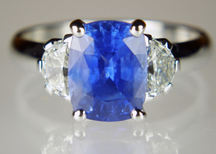 Sapphire & half moon diamond ring in 18ct white gold - Lady’s dress ring in 18ct white gold set with 3.32ct cushion cut blue sapphire from Sri Lanka and flanked by a matched 0.59ct pair of G/VS half moon diamonds.