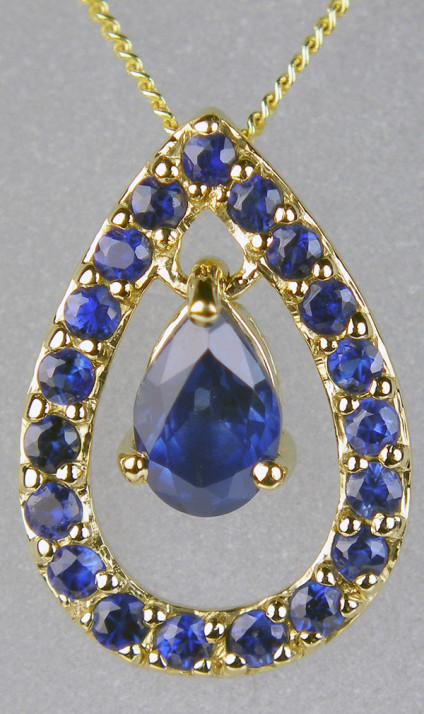 Sapphire pear shaped pendant in 9ct yellow gold - 0.83ct of sapphire in this stylish pear shaped pendant, made up of a single moving sapphire set in a sapphire set pear shaped frame in 9ct yellow gold, suspended from an 18" 9ct yellow gold chain. This striking pendant is 16mm long & 11mm wide.