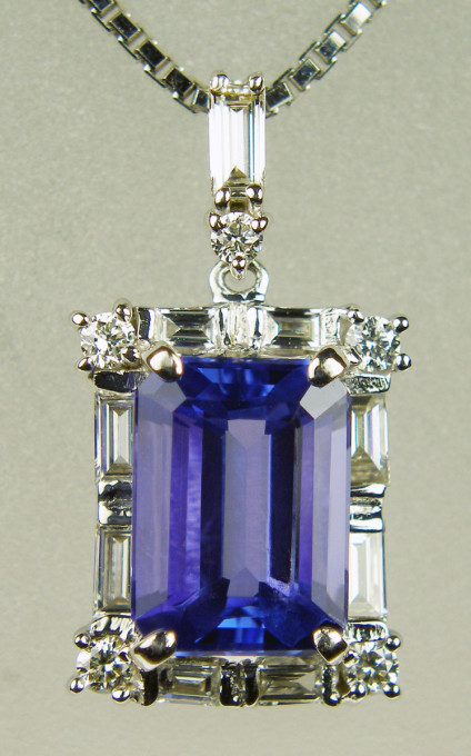 Tanzanite & diamond pendant in 18ct white gold - 2.55ct emerald cut tanzanite flanked by 0.32ct of baguette and round brilliant cut diamonds in H colour SI clarity and mounted in 18ct white gold on a length adjustable 18ct white gold chain. Pendant is 20mm long and 10mm wide