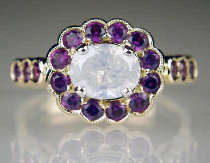 Milk white opalescent diamond & purple sapphire ring - 1ct oval milky white opalescent diamond surrounded by a halo of magenta purple sapphire rounds weighing 0.88ct and all mounted in an exquisite handmade 18ct rose gold ring