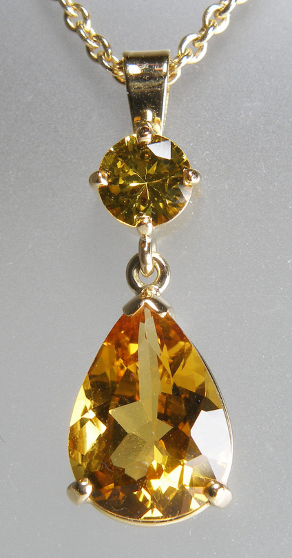 Yellow sapphire & heliodor, golden beryl pendant - Strikingly attractive pendant in 18ct yellow gold set with a 2.84ct pear cut golden beryl (heliodor) drop below a 0.59ct round brilliant cut natural yellow sapphire. Pendant is 26mm long and 9mm wide, it is suspended from a 20" 14ct yellow gold chain. Pendant is £1125, chain £265.